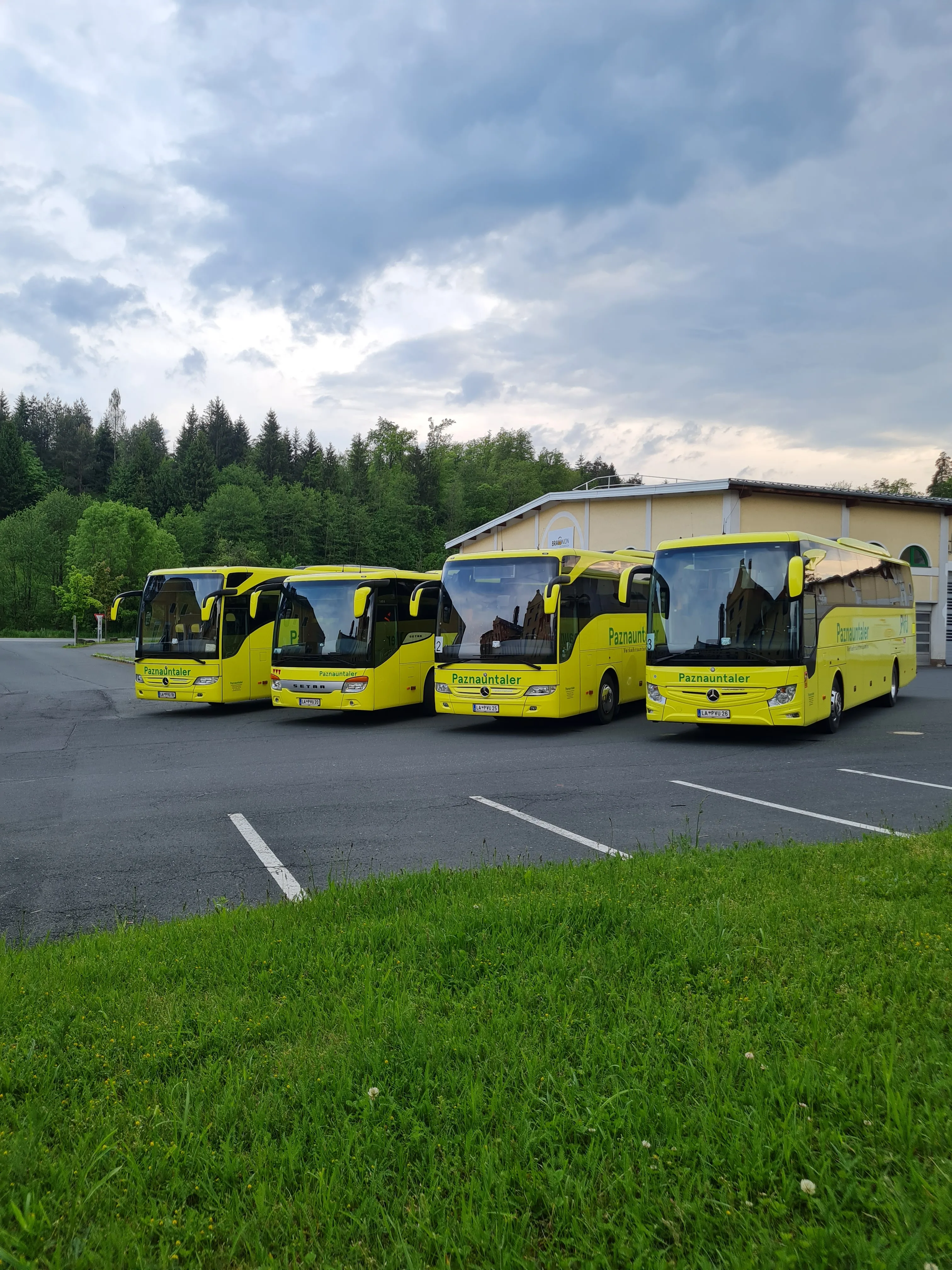 Vier gelbe Paznauntaler Reisebusse vor dem Firmendepot in Kappl, Tirol